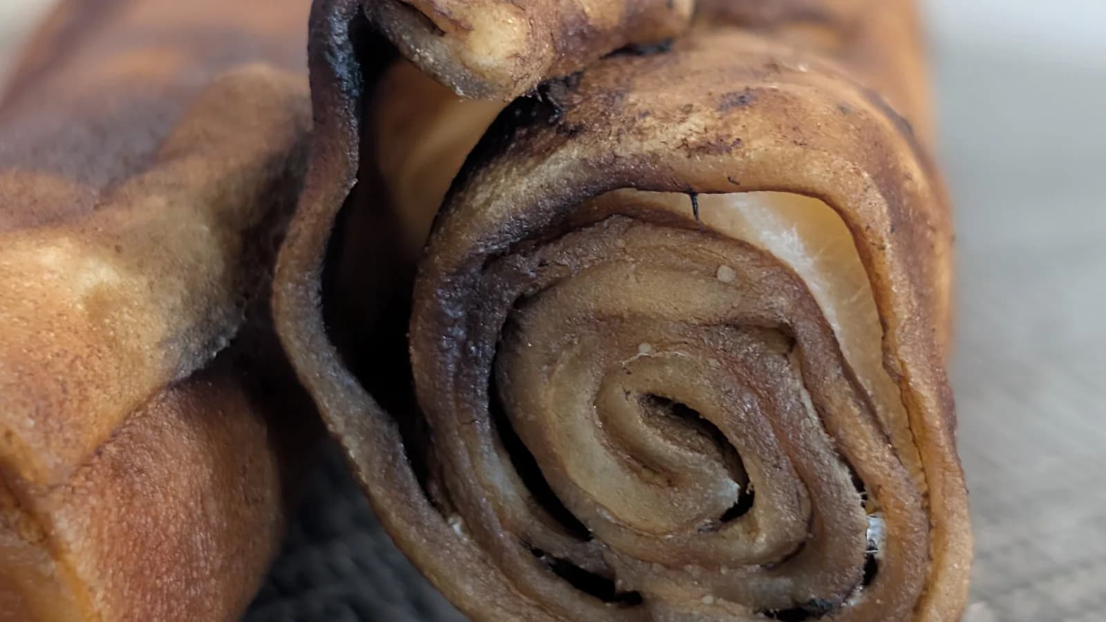 Cross-section of a ProHide Bully & Bacon Large Roll showing rolled beef hide layers