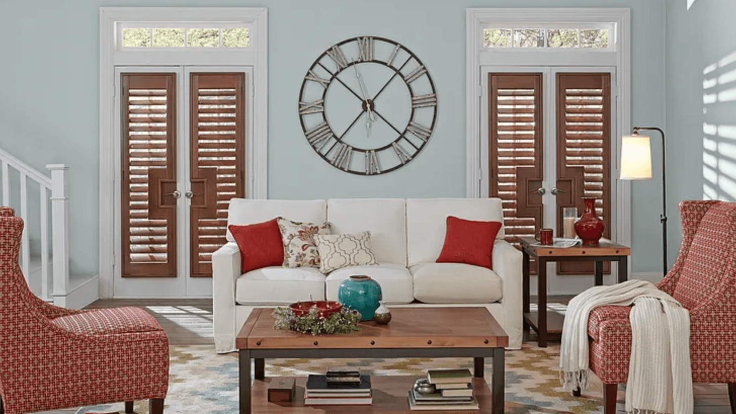 Living room with stylish brown plantation shutters on windows.